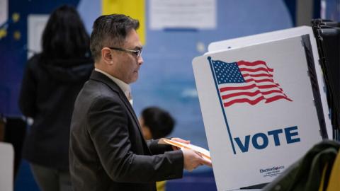 一名选民正在投票机上投票。（Samuel Corum / Getty Images）